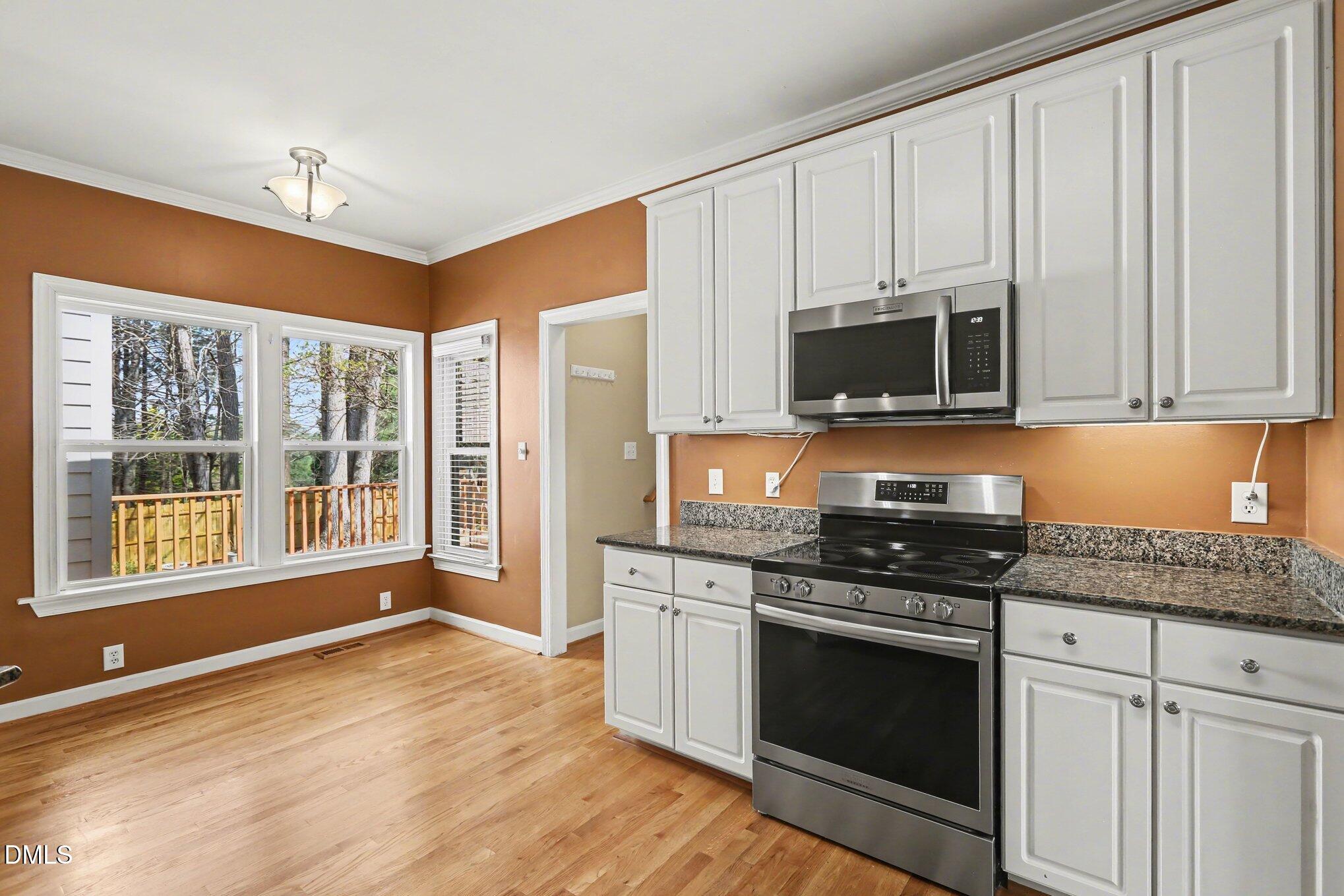 2616 Jasper Lane Raleigh, NC 27613 - Photo 14 of 44 a kitchen with stainless steel appliances granite countertop a stove a sink and a microwave