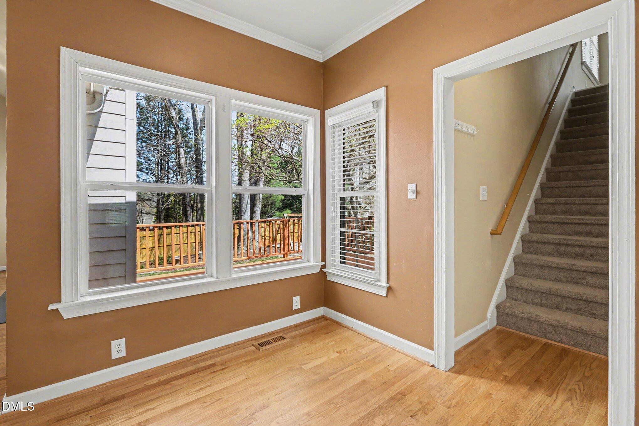 2616 Jasper Lane Raleigh, NC 27613 - Photo 16 of 44 a view of an empty room with wooden floor and windows