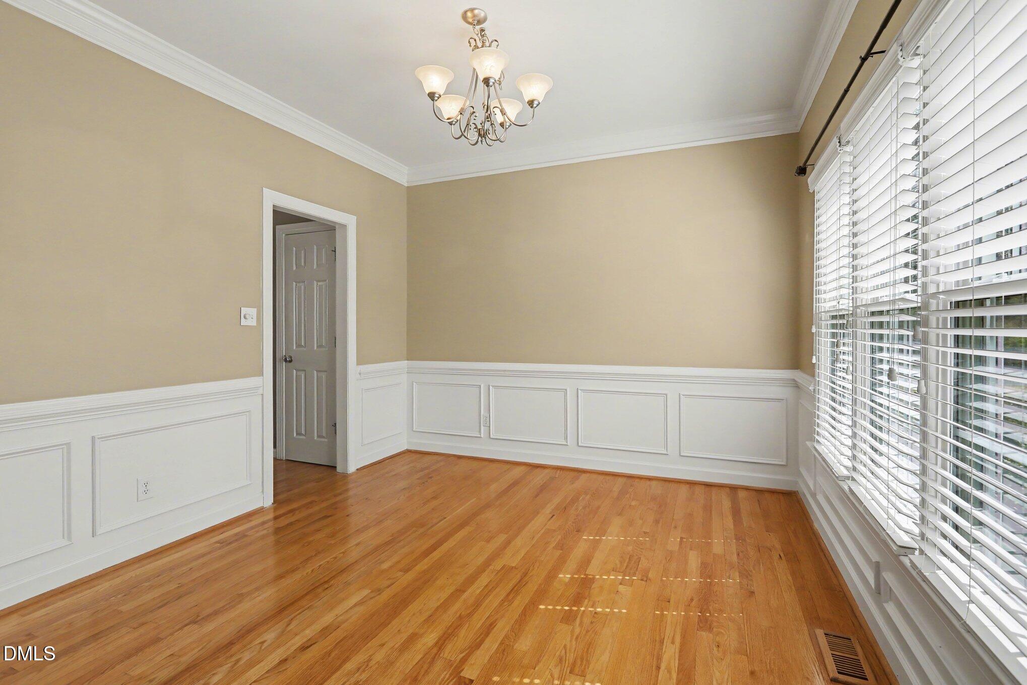 2616 Jasper Lane Raleigh, NC 27613 - Photo 8 of 44 a view of an empty room with a window and wooden floor