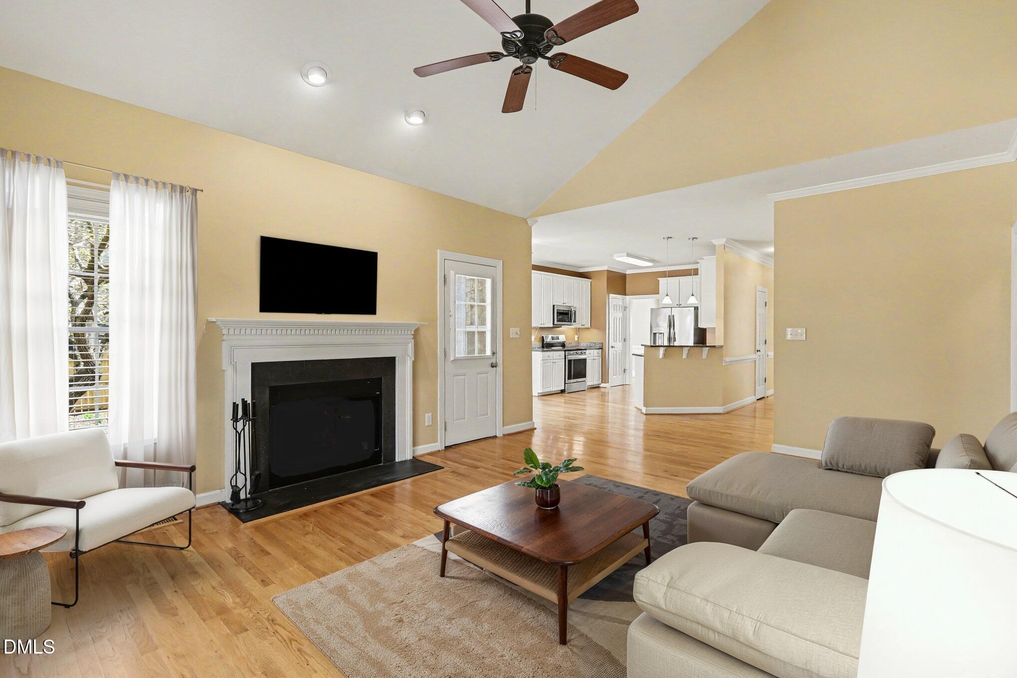 2616 Jasper Lane Raleigh, NC 27613 - Photo 9 of 44 a living room with furniture a fireplace and a flat screen tv