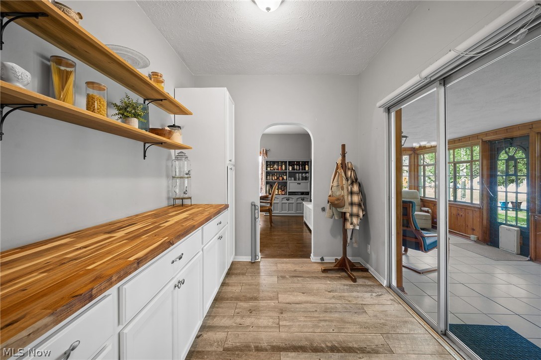 2420 Copley Road Akron, OH 44321 - Photo 11 of 44 Kitchen featuring light tile floors, wood counters, white cabinetry, and a textured ceiling