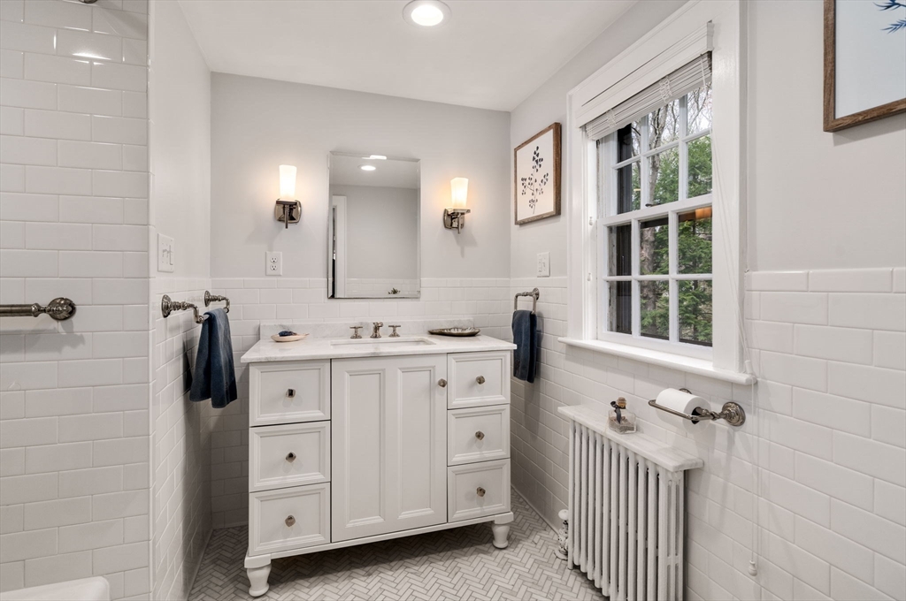 17 Roberts Road Wellesley, MA 02481 - Photo 21 of 34 a bathroom with a double vanity sink a mirror and a bathtub