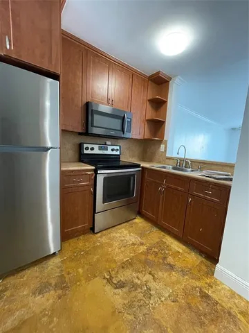 a kitchen with stainless steel appliances granite countertop a sink stove and refrigerator