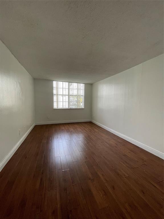 492 Northwest 165th Street Miami, FL 33169 - Photo 18 of 27 a view of an empty room with wooden floor and window