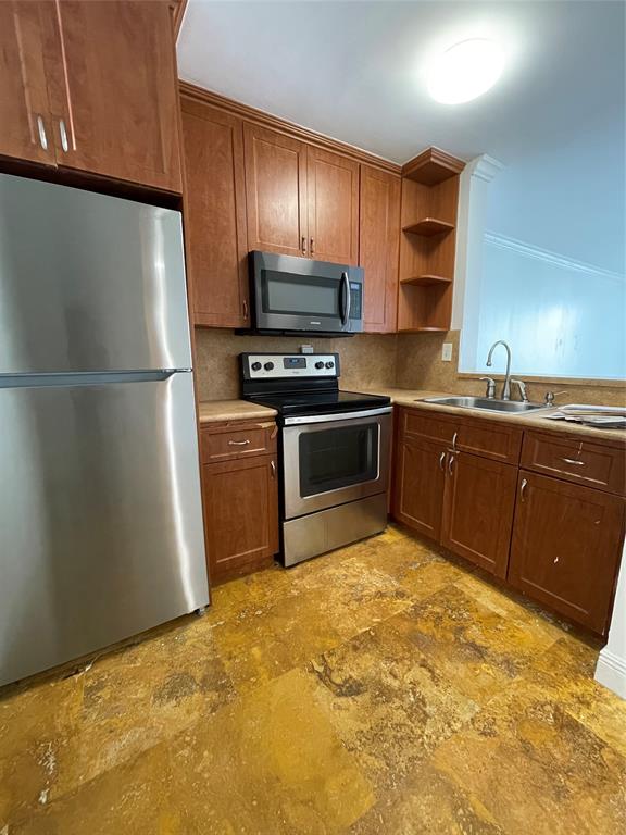 492 Northwest 165th Street Miami, FL 33169 - Photo 3 of 27 a kitchen with stainless steel appliances granite countertop a refrigerator sink and stove