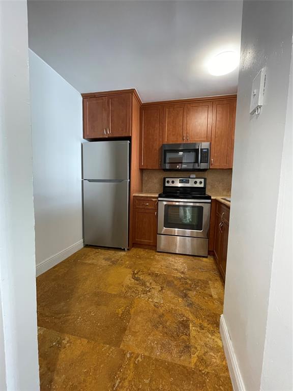 492 Northwest 165th Street Miami, FL 33169 - Photo 4 of 27 a kitchen with a refrigerator and a stove top oven