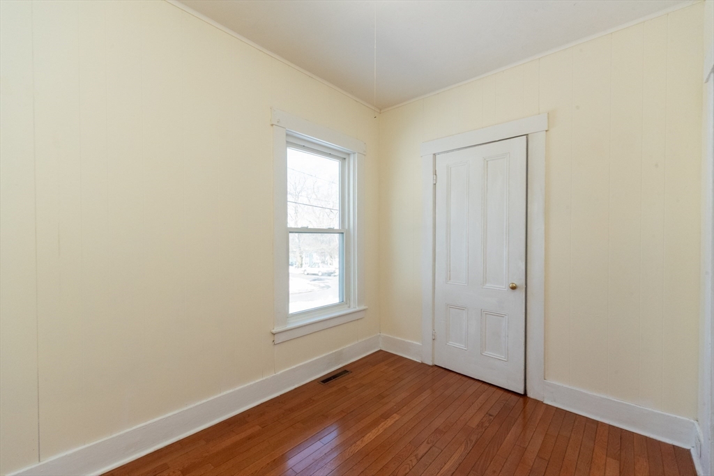85 Beacon Street Clinton, MA 01510 - Photo 14 of 39 an empty room with wooden floor and windows