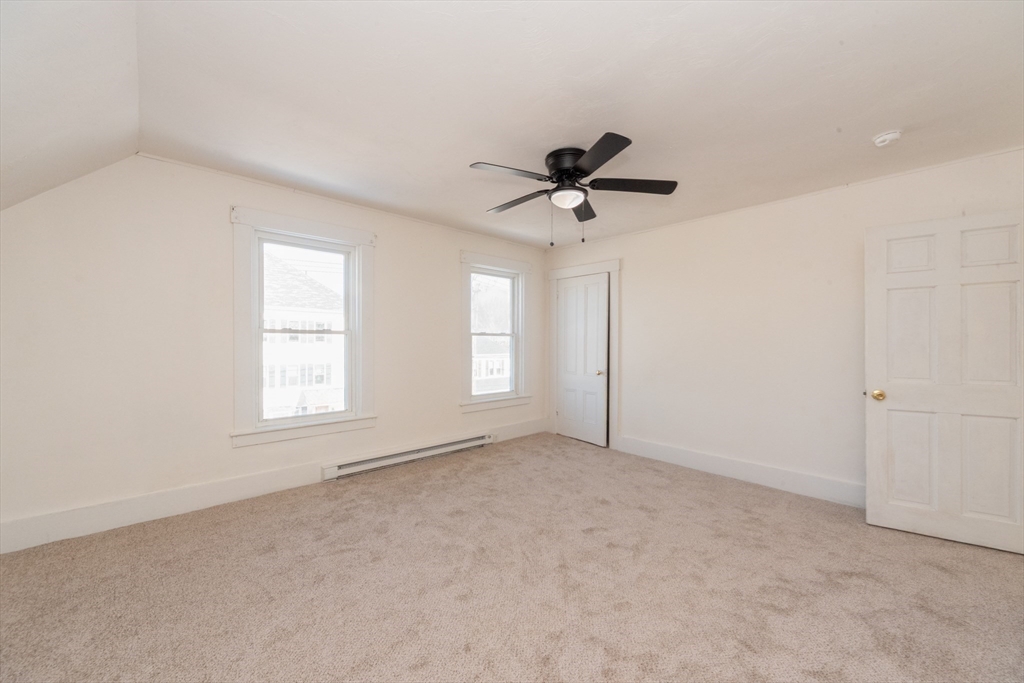 85 Beacon Street Clinton, MA 01510 - Photo 19 of 39 an empty room with a ceiling fan and windows