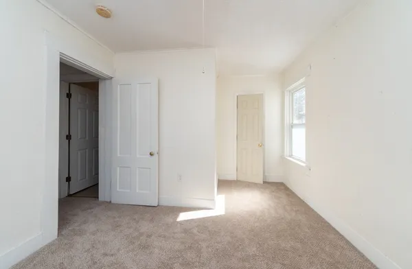 an empty room with windows and closet