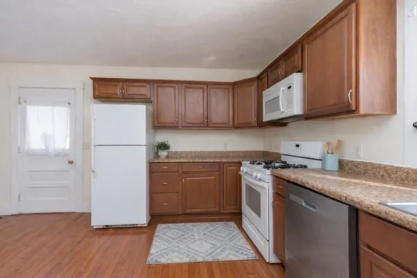 a kitchen with stainless steel appliances granite countertop a refrigerator a stove a sink and a microwave