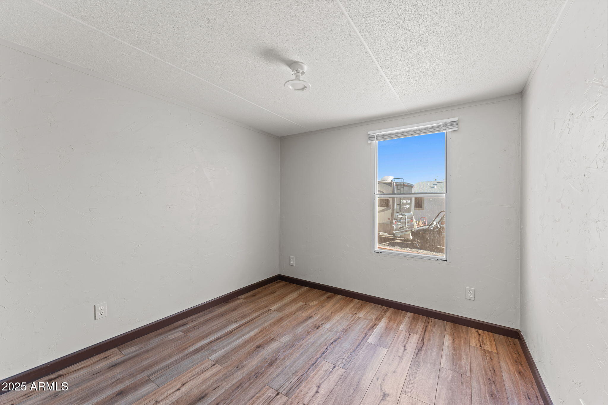 21199 West Escapee Way Congress, AZ 85332 - Photo 13 of 23 a view of empty room with wooden floor and fan