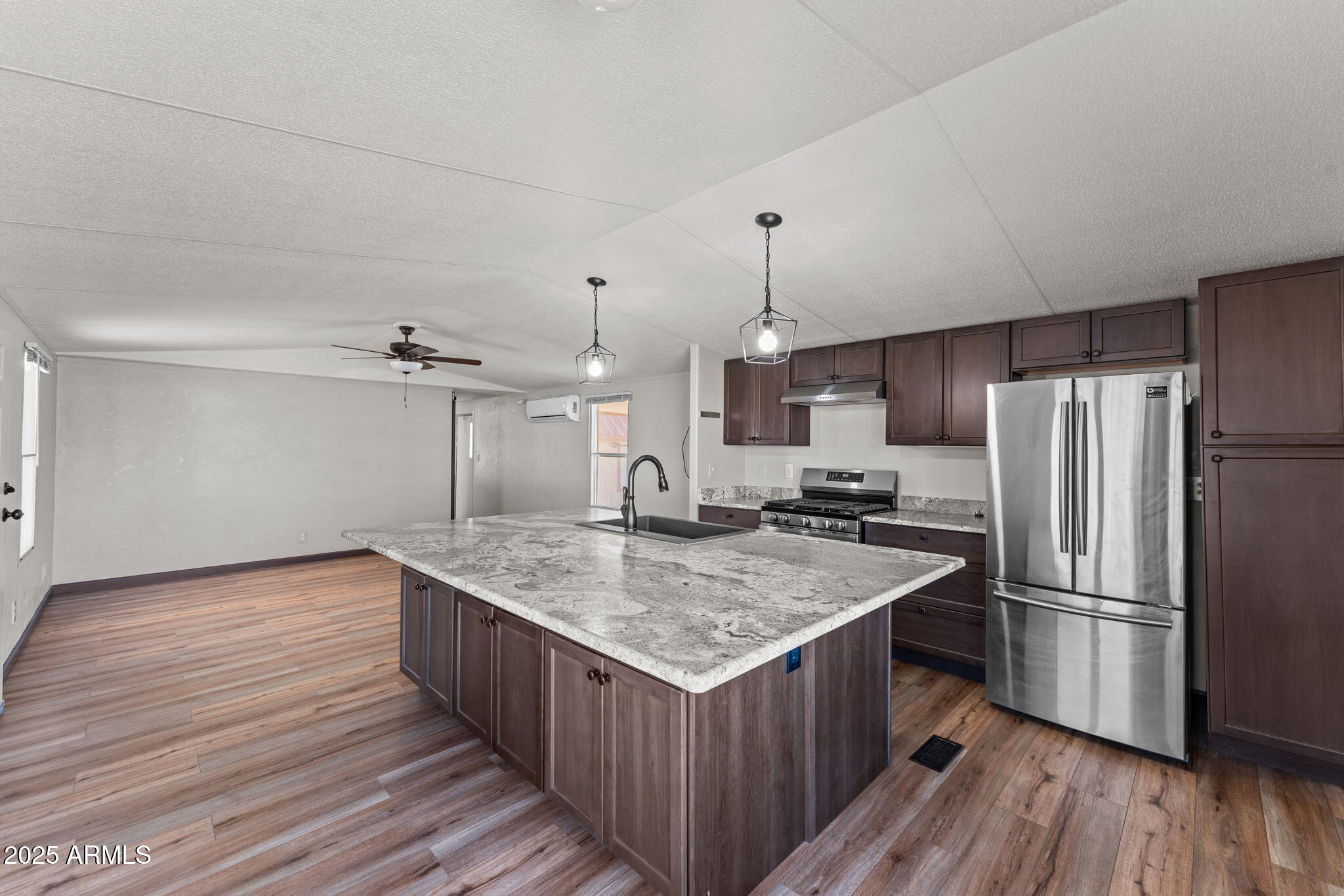 21199 West Escapee Way Congress, AZ 85332 - Photo 4 of 23 a kitchen with kitchen island a sink wooden floor and stainless steel appliances