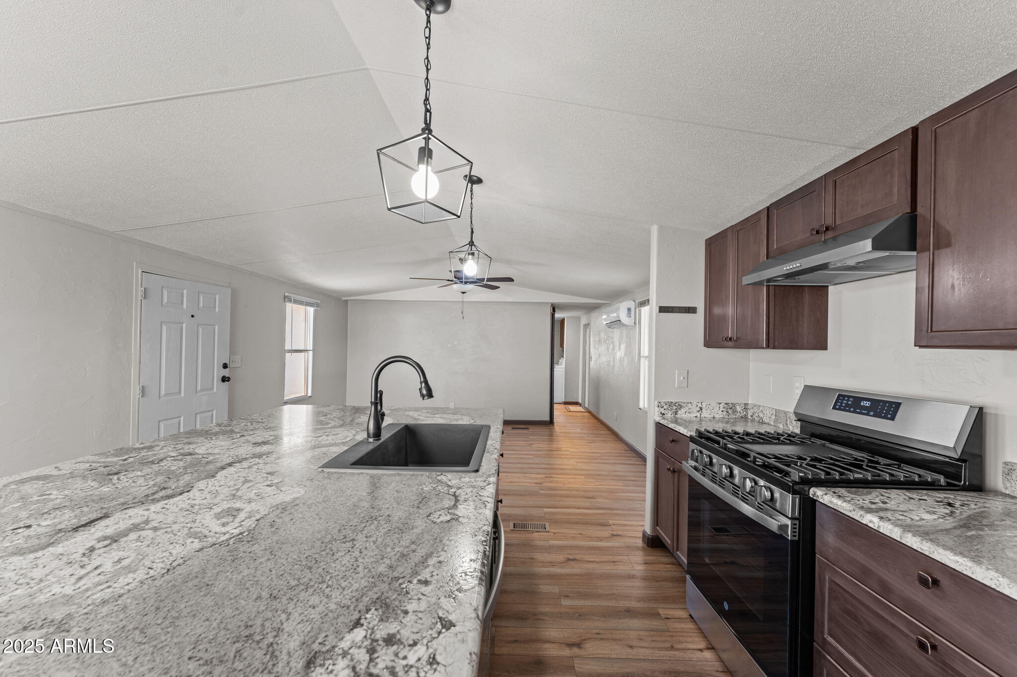 21199 West Escapee Way Congress, AZ 85332 - Photo 6 of 23 a kitchen with stainless steel appliances granite countertop a stove top oven a sink a counter space and cabinets