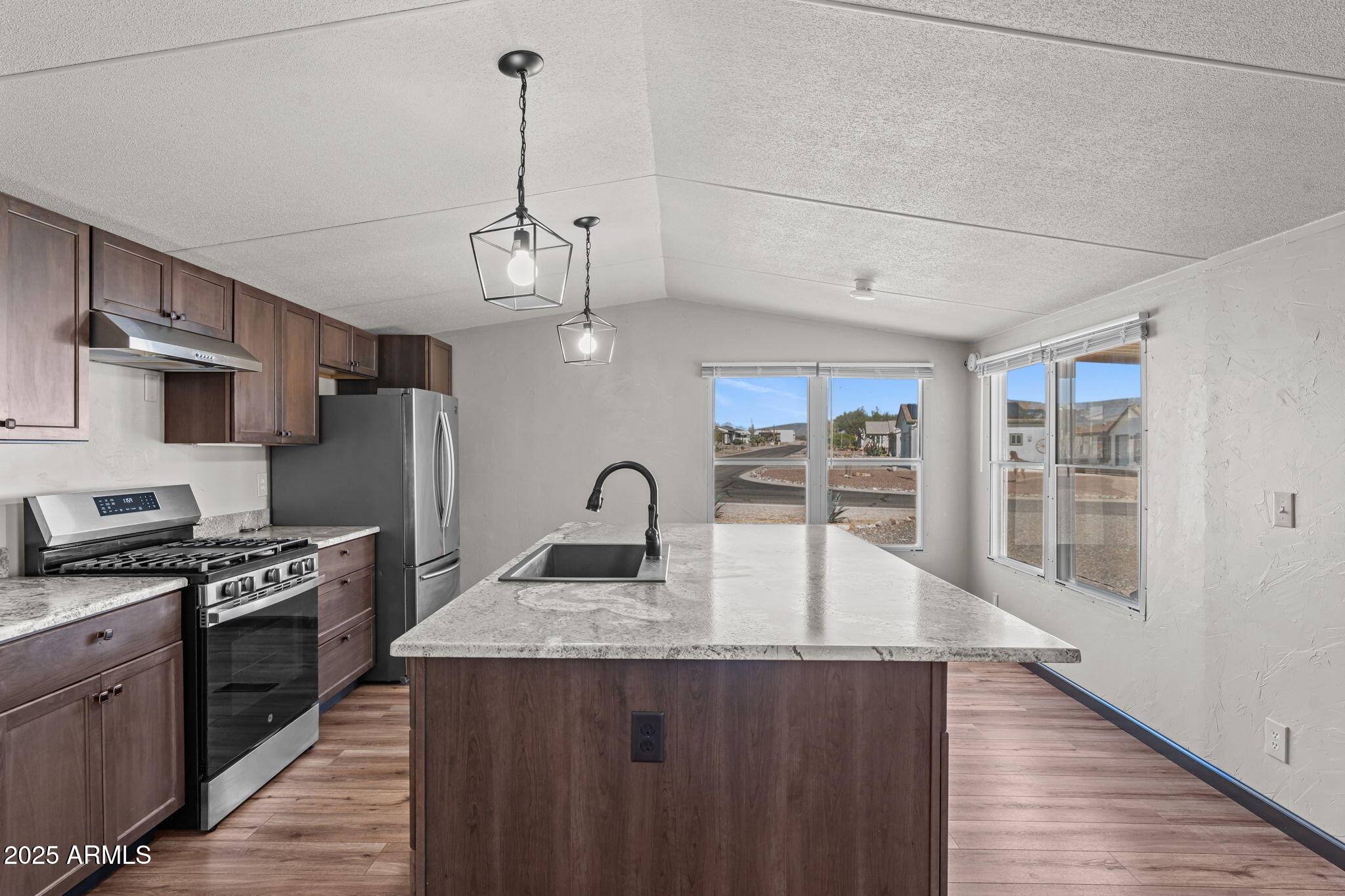 21199 West Escapee Way Congress, AZ 85332 - Photo 7 of 23 a kitchen with stainless steel appliances granite countertop a sink a stove and a wooden floors