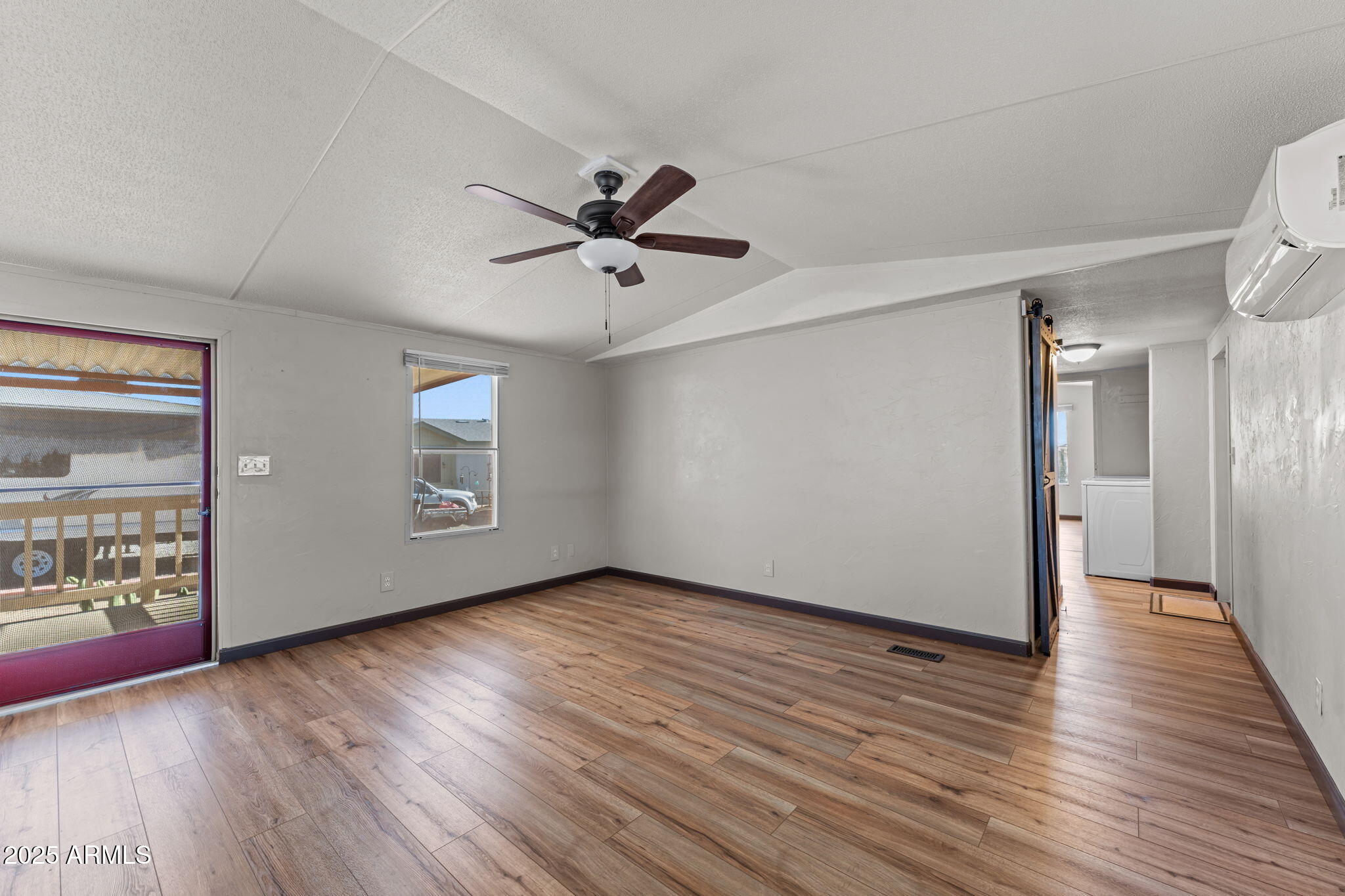 21199 West Escapee Way Congress, AZ 85332 - Photo 8 of 23 a view of an empty room with wooden floor and a window