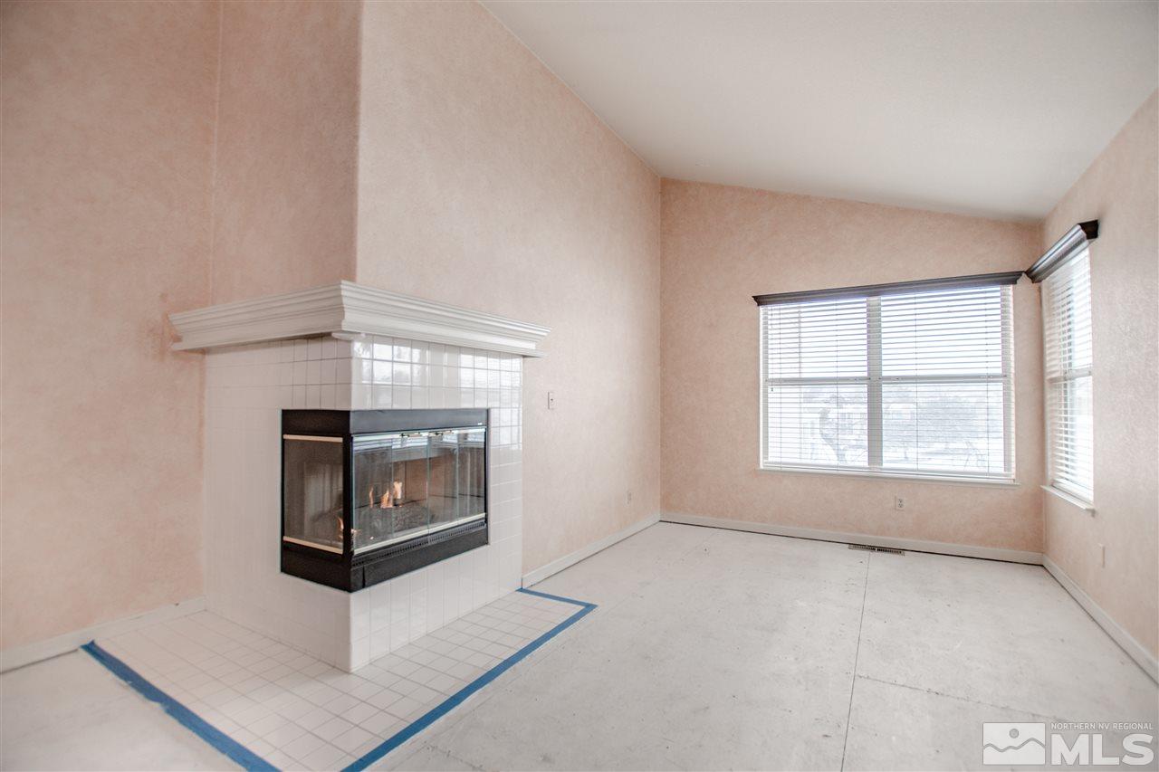 6174 Carriage House Way Reno, NV 89519 - Photo 12 of 22 an empty room with windows and fireplace