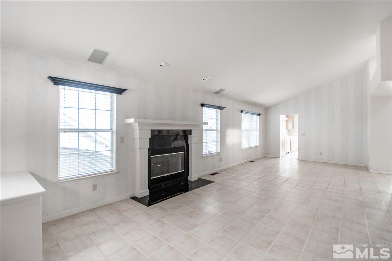 6174 Carriage House Way Reno, NV 89519 - Photo 8 of 22 an empty room with windows and fireplace