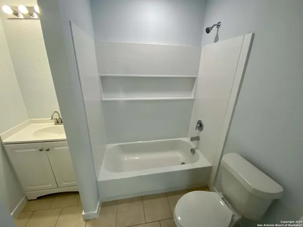 a white toilet sitting next to a bath tub
