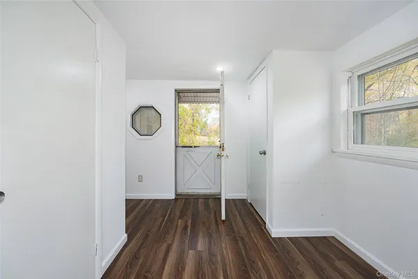 a view of a room with wooden floor a ceiling fan and windows