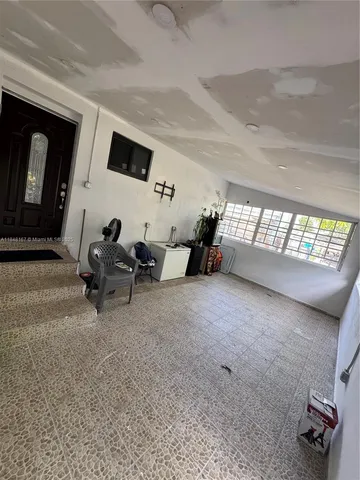 a view of a patio with table and chairs potted plants and a large tree