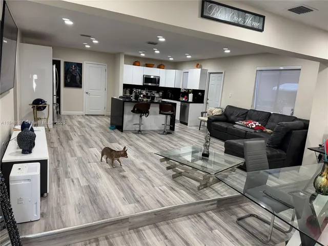 a living room with furniture and kitchen view