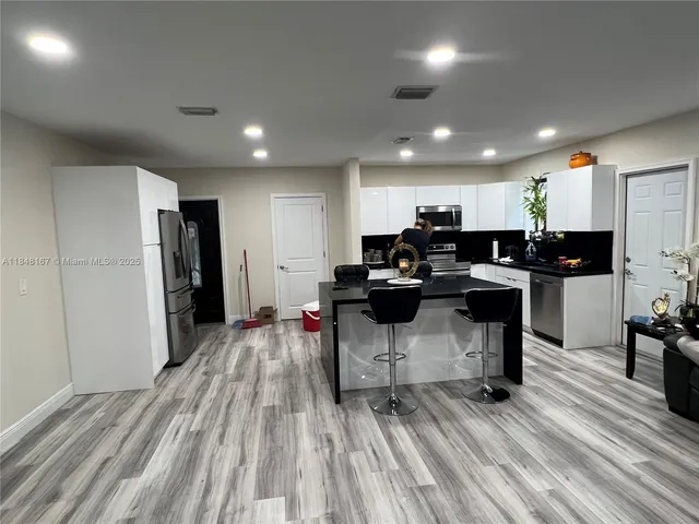a view of kitchen with refrigerator stove microwave and cabinets