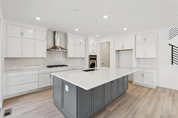 a kitchen with stainless steel appliances granite countertop a table and chairs in it