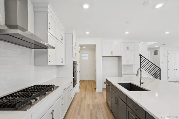 a large kitchen with stainless steel appliances granite countertop a large counter top and a stove top oven
