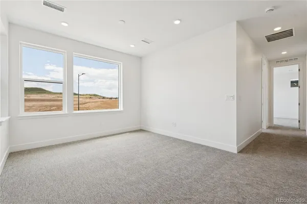 a view of a hallway with wooden floor and a window