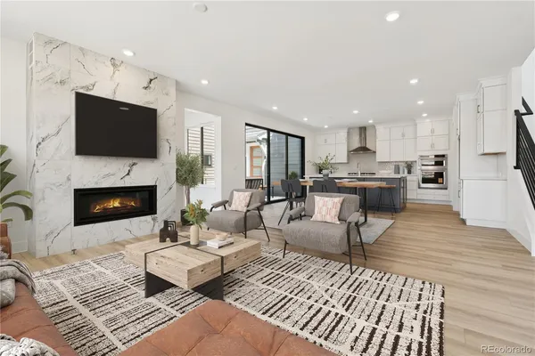 a living room with furniture fireplace and a large window