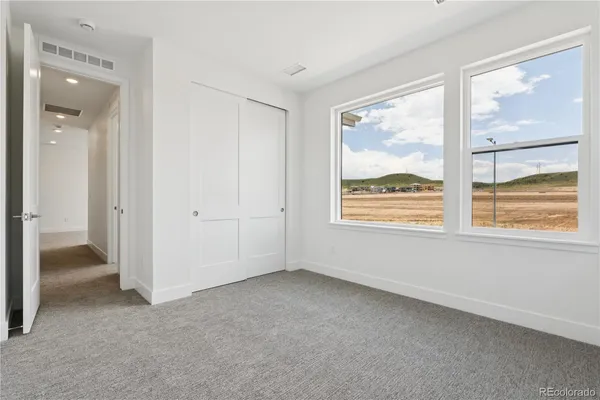 an empty room with windows and closet