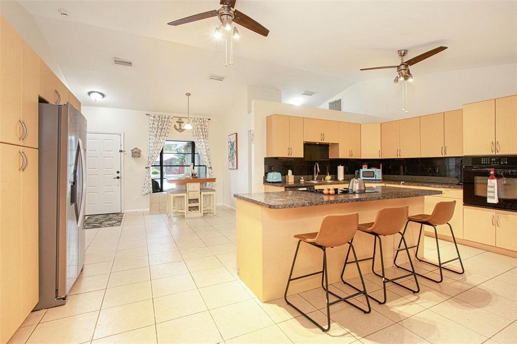 4105 Spring Way Circle Valrico, FL 33596 - Photo 11 of 34 a kitchen with stainless steel appliances kitchen island granite countertop a refrigerator and microwave