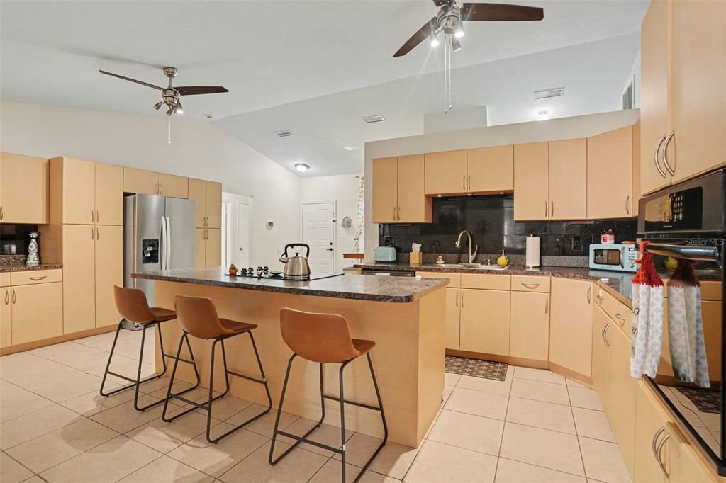 4105 Spring Way Circle Valrico, FL 33596 - Photo 15 of 34 a kitchen with stainless steel appliances kitchen island granite countertop a refrigerator a stove a sink dishwasher and white cabinets with wooden floor
