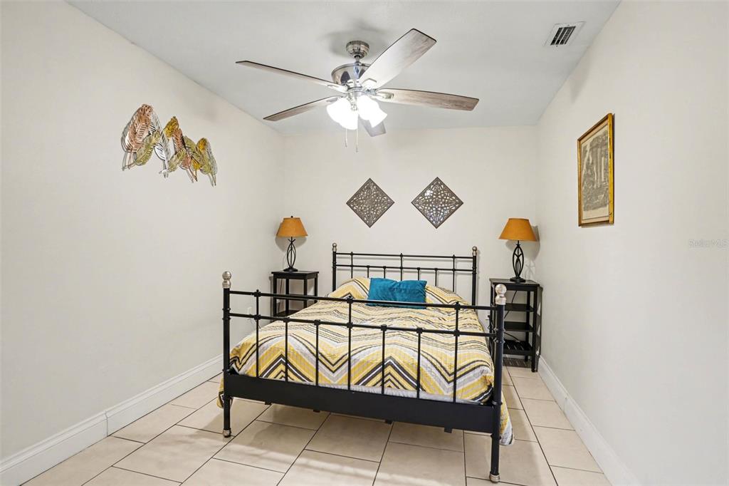 4105 Spring Way Circle Valrico, FL 33596 - Photo 21 of 34 a bedroom with a bed and a chandelier