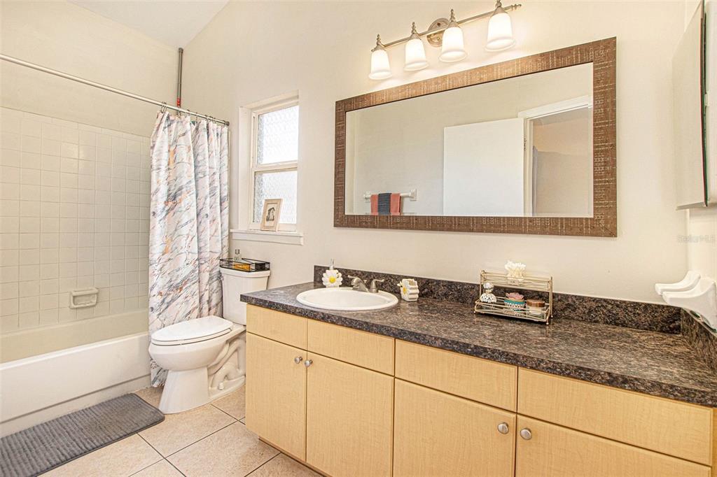 4105 Spring Way Circle Valrico, FL 33596 - Photo 24 of 34 a bathroom with a granite countertop sink a toilet a mirror and shower