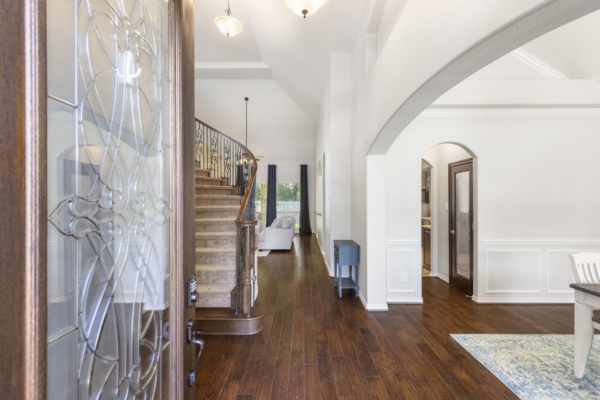 19819 Iceland Court Spring, TX 77379 - Photo 3 of 42 Step into the grand foyer featuring sweeping archways, rich hardwood floors, and high ceilings.