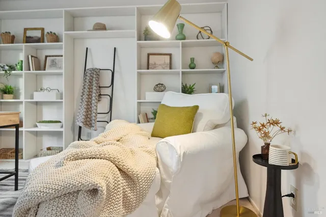 a bed sitting in a bedroom next to a book shelf