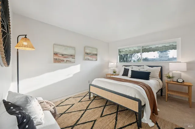 a bedroom with a bed and a lamp next to a window