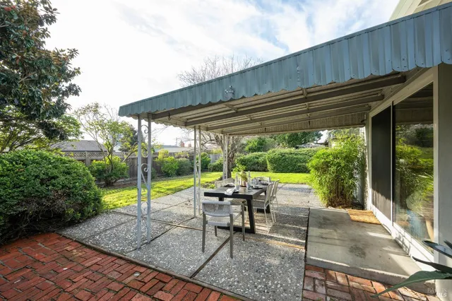 a view of a patio with a table chairs and a backyard