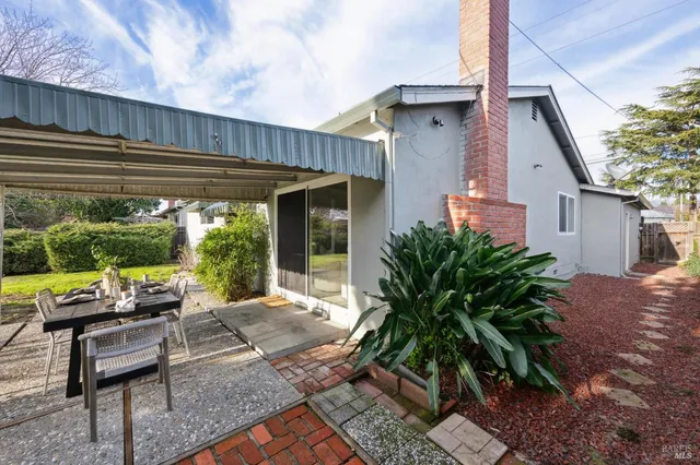 a view of a house with backyard sitting area and garden