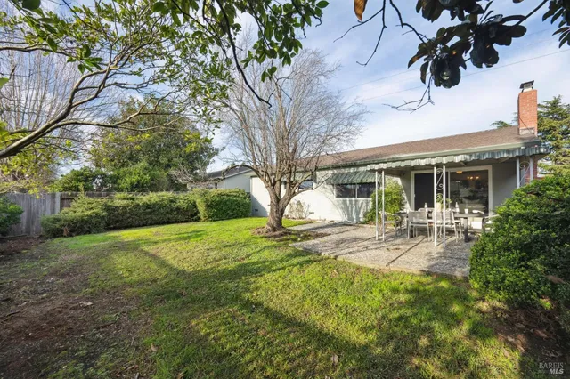 a view of a house with backyard and sitting area