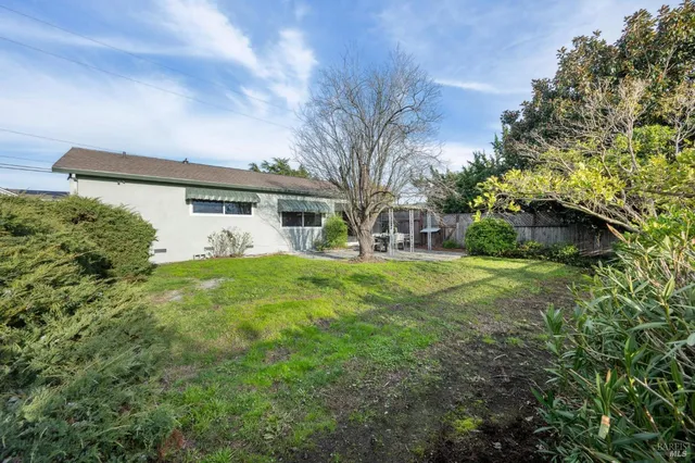 a front view of a house with garden and trees