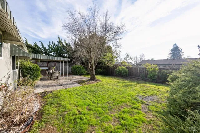 a view of a house with backyard and a sitting area