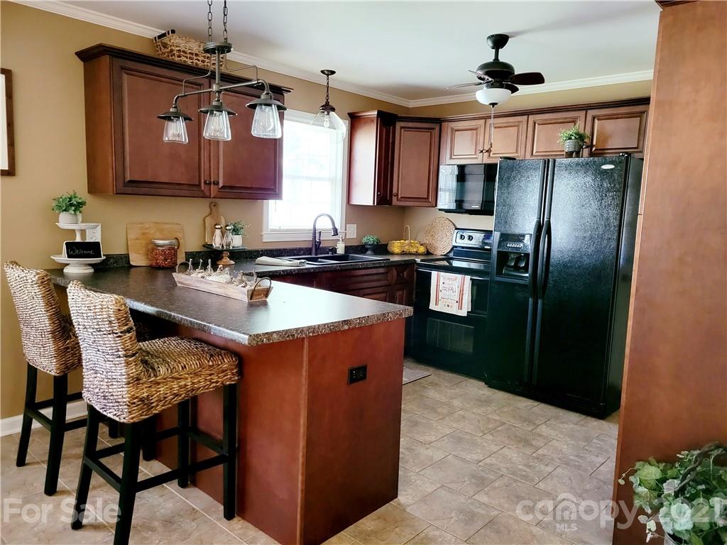 3411 Fallston Road Shelby, NC 28150 - Photo 9 of 39 a kitchen with stainless steel appliances granite countertop a refrigerator a sink a stove a dining table and chairs