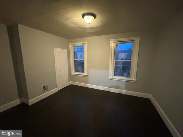 an empty room with wooden floor and entrance