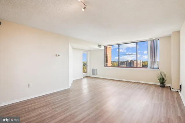 an empty room with wooden floor and closet