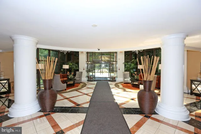 a view of a hallway with wooden floor and a bathroom