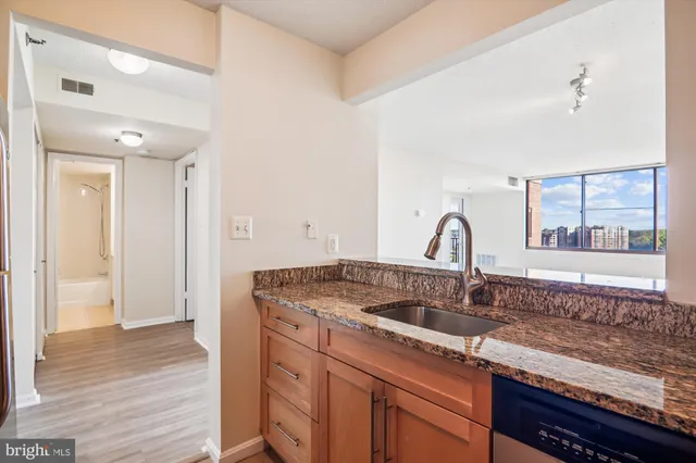 a kitchen with granite countertop a sink stainless steel appliances and cabinets
