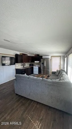 a living room with stainless steel appliances kitchen island granite countertop furniture and a fireplace