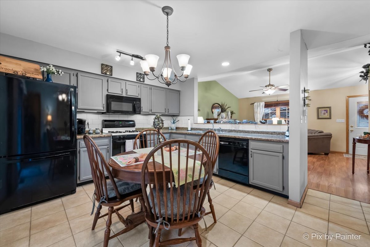 705 Cherry Tree Lane Genoa, IL 60135 - Photo 3 of 31 a kitchen with stainless steel appliances granite countertop a sink a stove a table and chairs